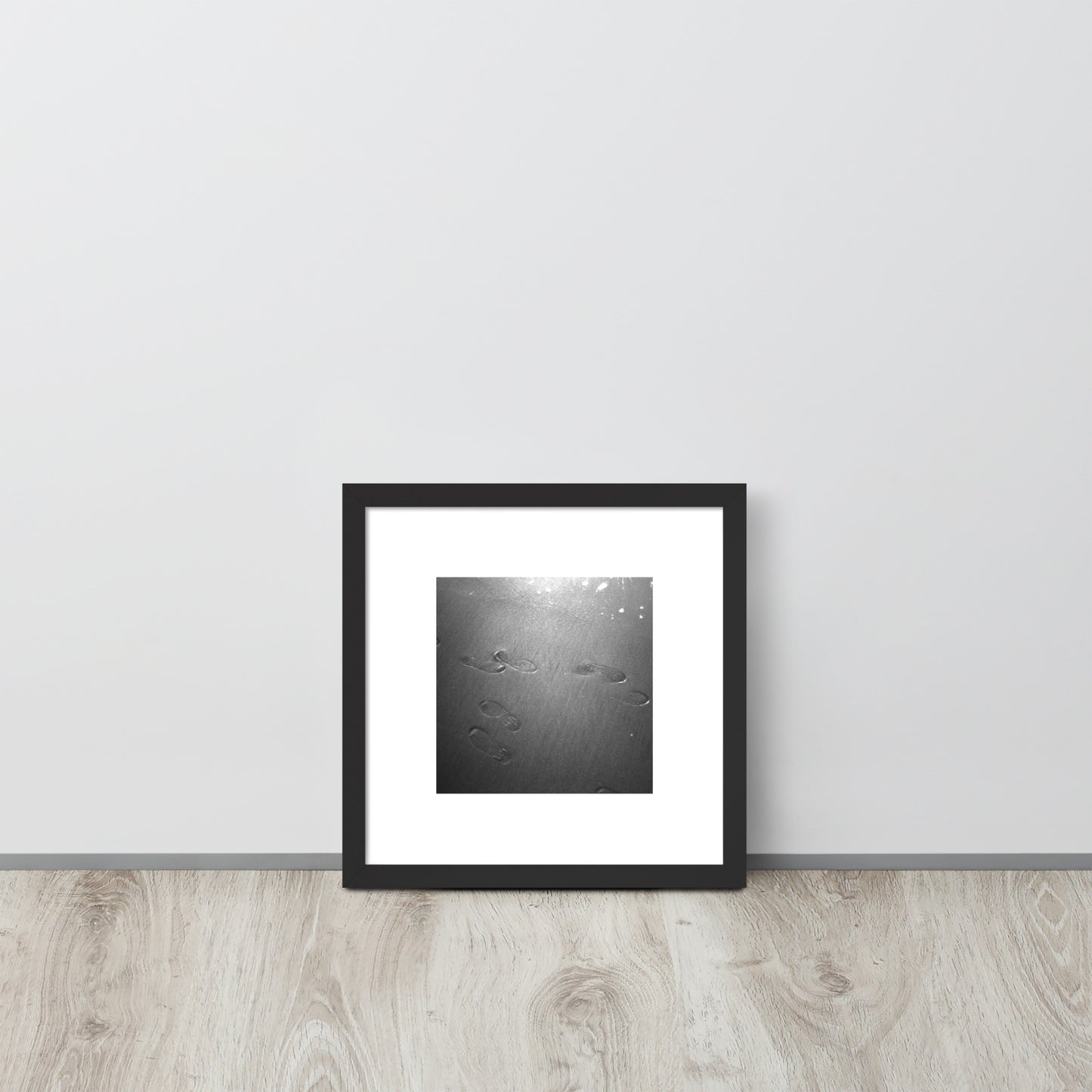 Minimalist art featuring the 'Beach Footprints (B&W)' photo art in a black matte frame. / 「砂浜の足跡（モノクロ）」のフォトアートを収めた、ブラックフレームの額装品。