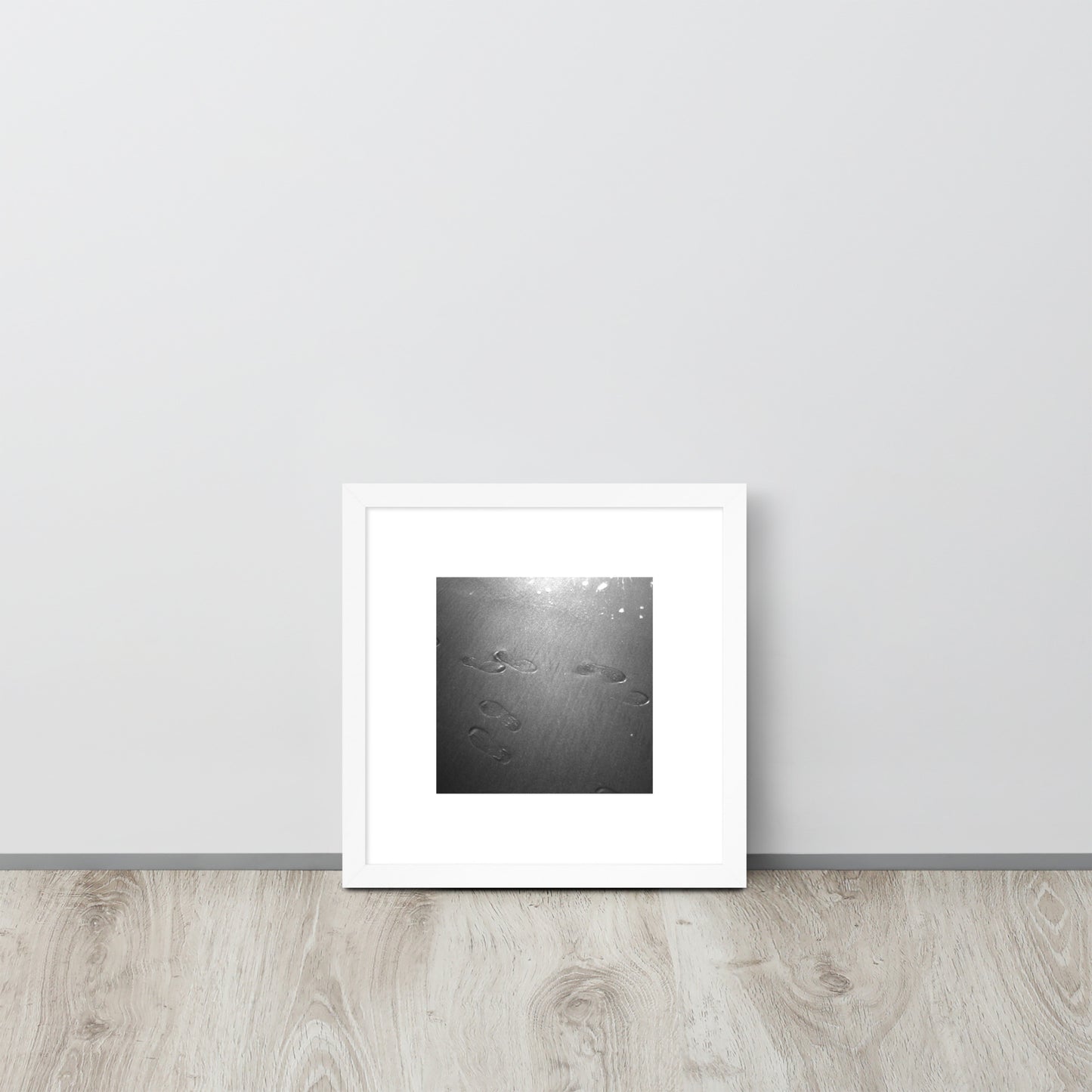 Minimalist art featuring the 'Beach Footprints (B&W)' photo art in a white matte frame. / 「砂浜の足跡（モノクロ）」のフォトアートを収めた、ホワイトフレームの額装品。