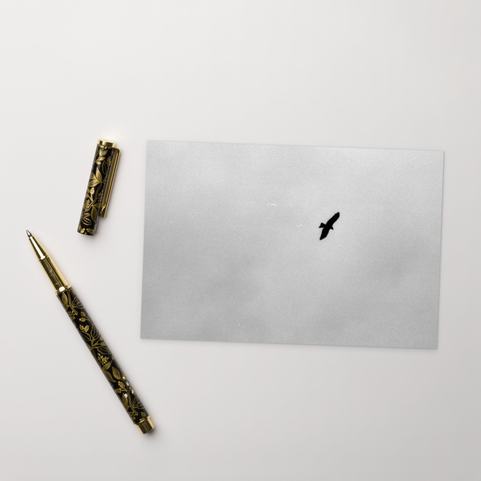 Lifestyle shot of a person holding the 'Bird and Sky (B&W)' postcard, highlighting its thick, high-quality matte paper texture. / 「Bird and Sky (B&W)」ポストカード：手に馴染む厚手のマット紙を使用したポストカード。大切な人へのメッセージカードとしてはもちろん、ミニ・アートとしても楽しめます。