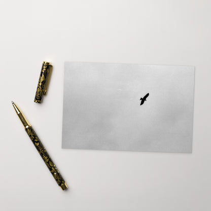 Lifestyle shot of a person holding the 'Bird and Sky (B&W)' postcard, highlighting its thick, high-quality matte paper texture. / 「Bird and Sky (B&W)」ポストカード：手に馴染む厚手のマット紙を使用したポストカード。大切な人へのメッセージカードとしてはもちろん、ミニ・アートとしても楽しめます。